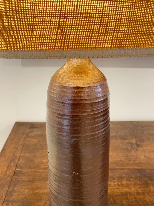 A tall hand wheel thrown stoneware lamp