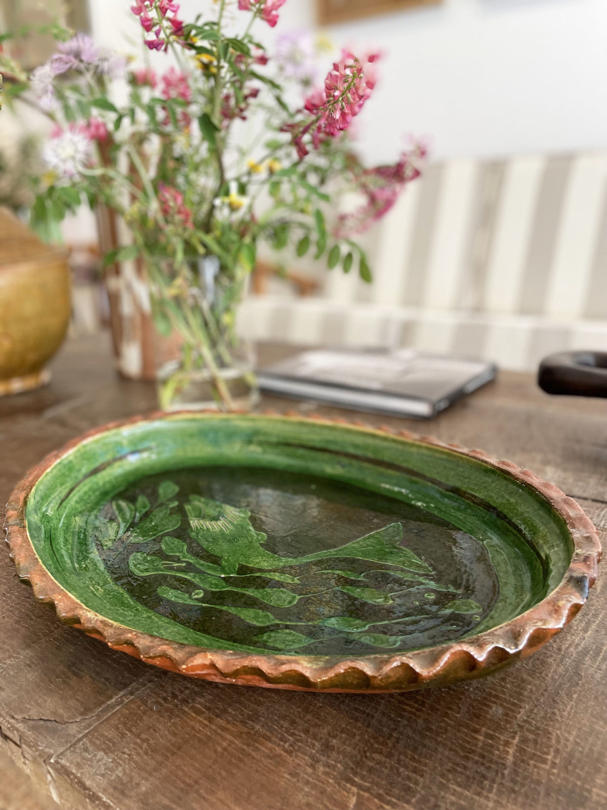 Large green glazed ceramic dish with a fish