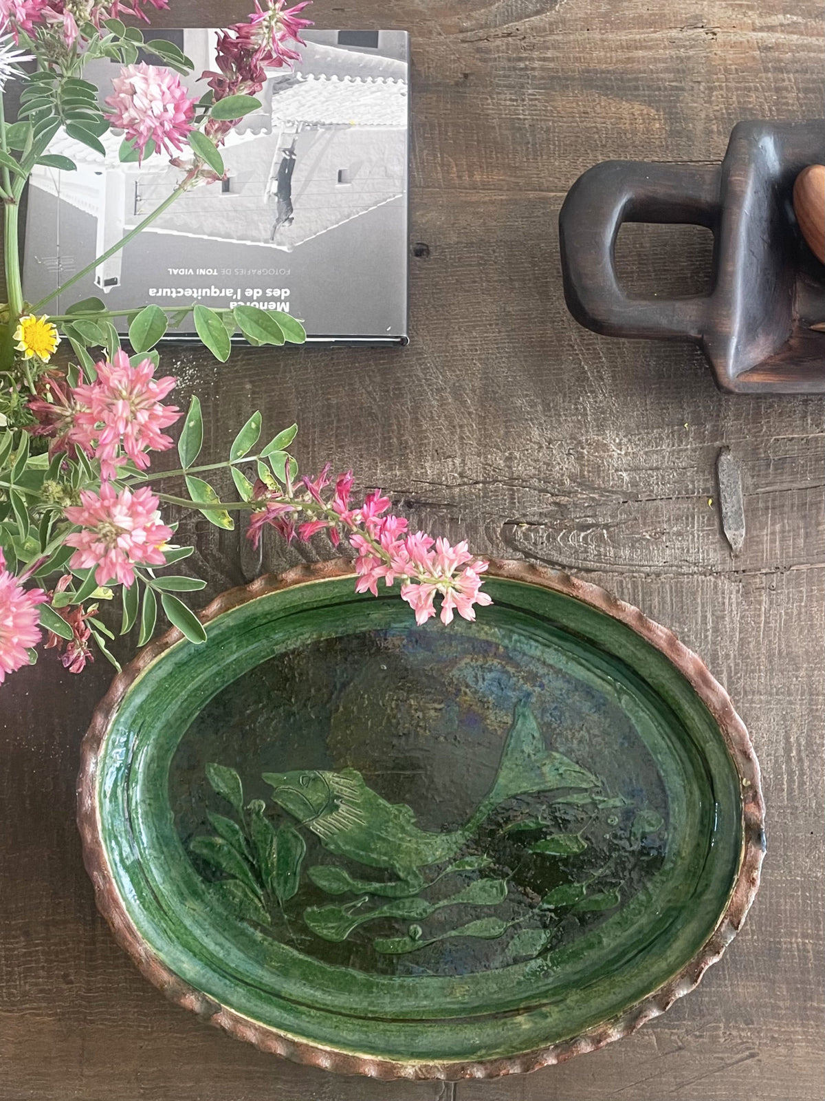 Large green glazed ceramic dish with a fish