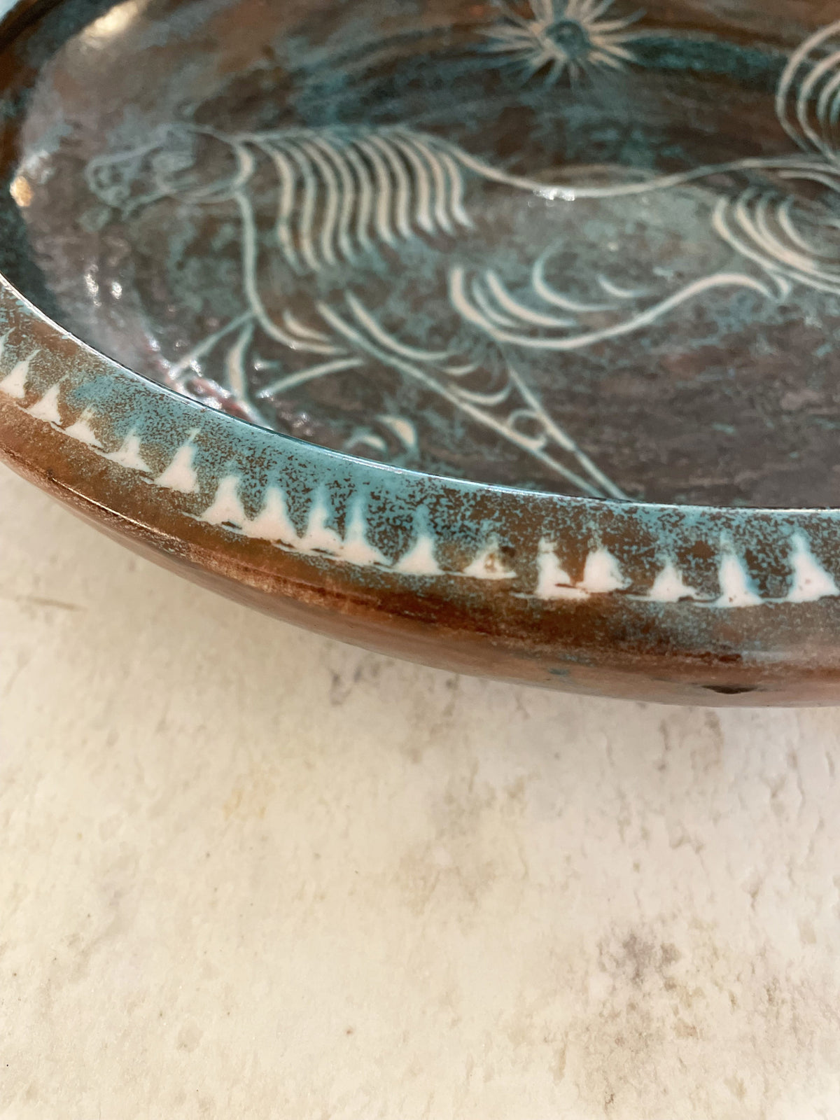 Large turquoise blue glazed ceramic bowl with a horse