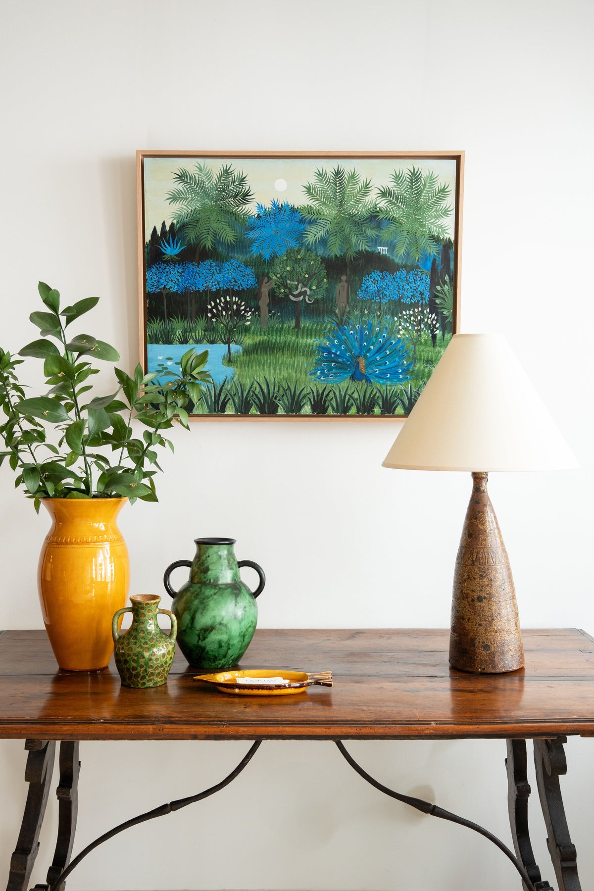 Walnut table with glazed ceramics, lamp and naive painting